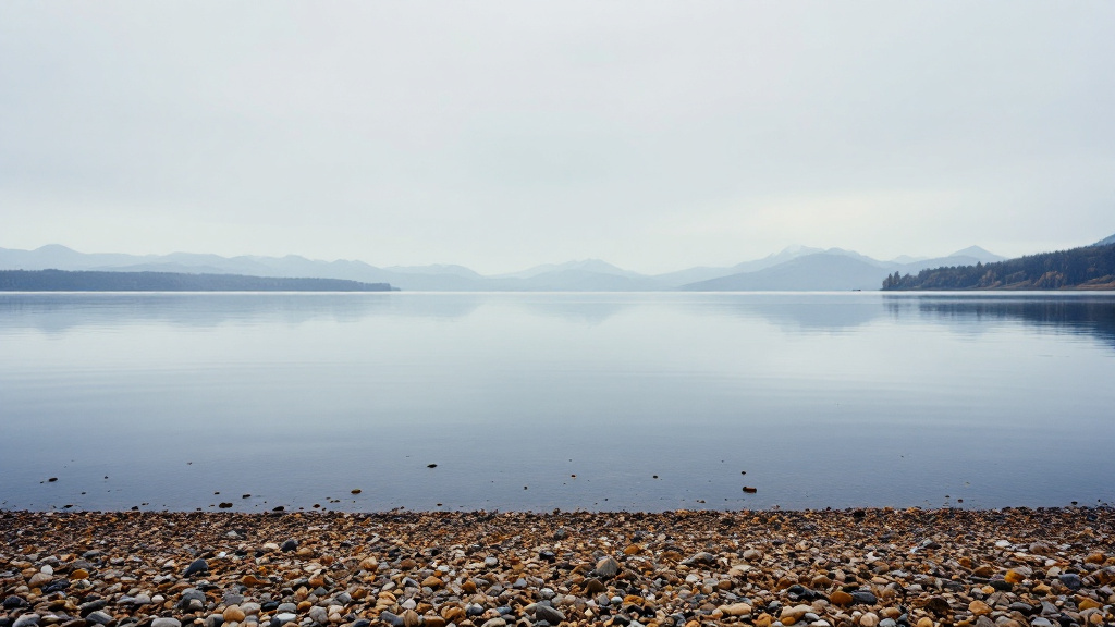 Chiemsee vom Nordufer aus mit Kiesufer, in der Ferne die Chiemgauer Alpen