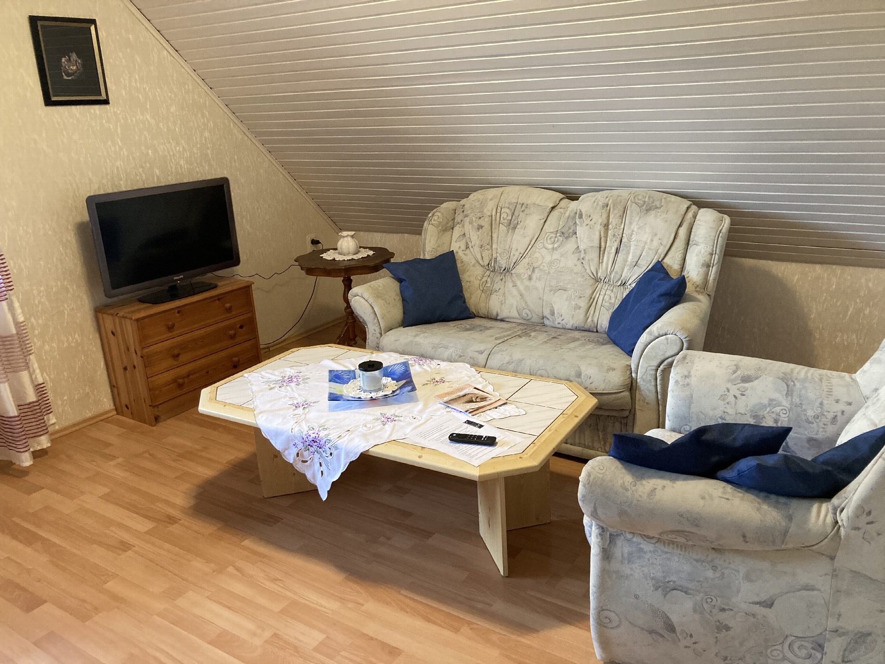Wohnzimmer mit Couch, zwei Sesseln und Fernseher