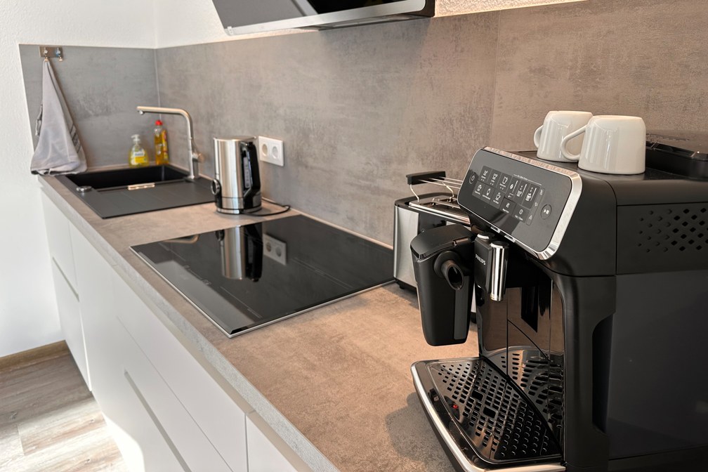 Küche mit Kochfeld, Wasserkocher und Kaffeemaschine