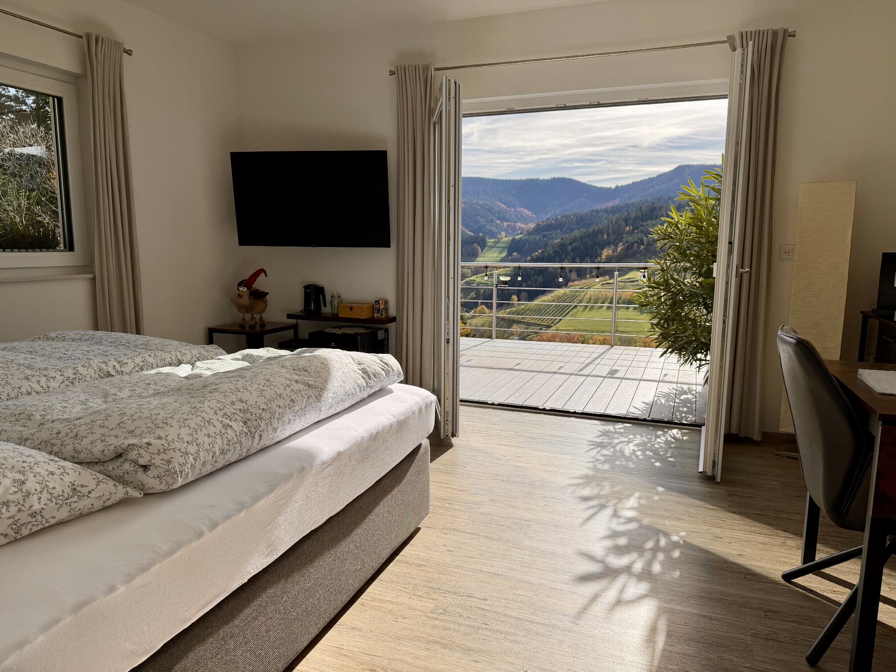 Gästezimmer mit Boxspringbett und Tür zur Terrasse