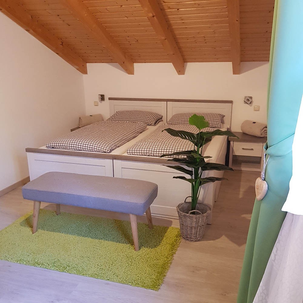 Schlafzimmer unter dem Dach mit Doppelbett aus zwei Matratzen