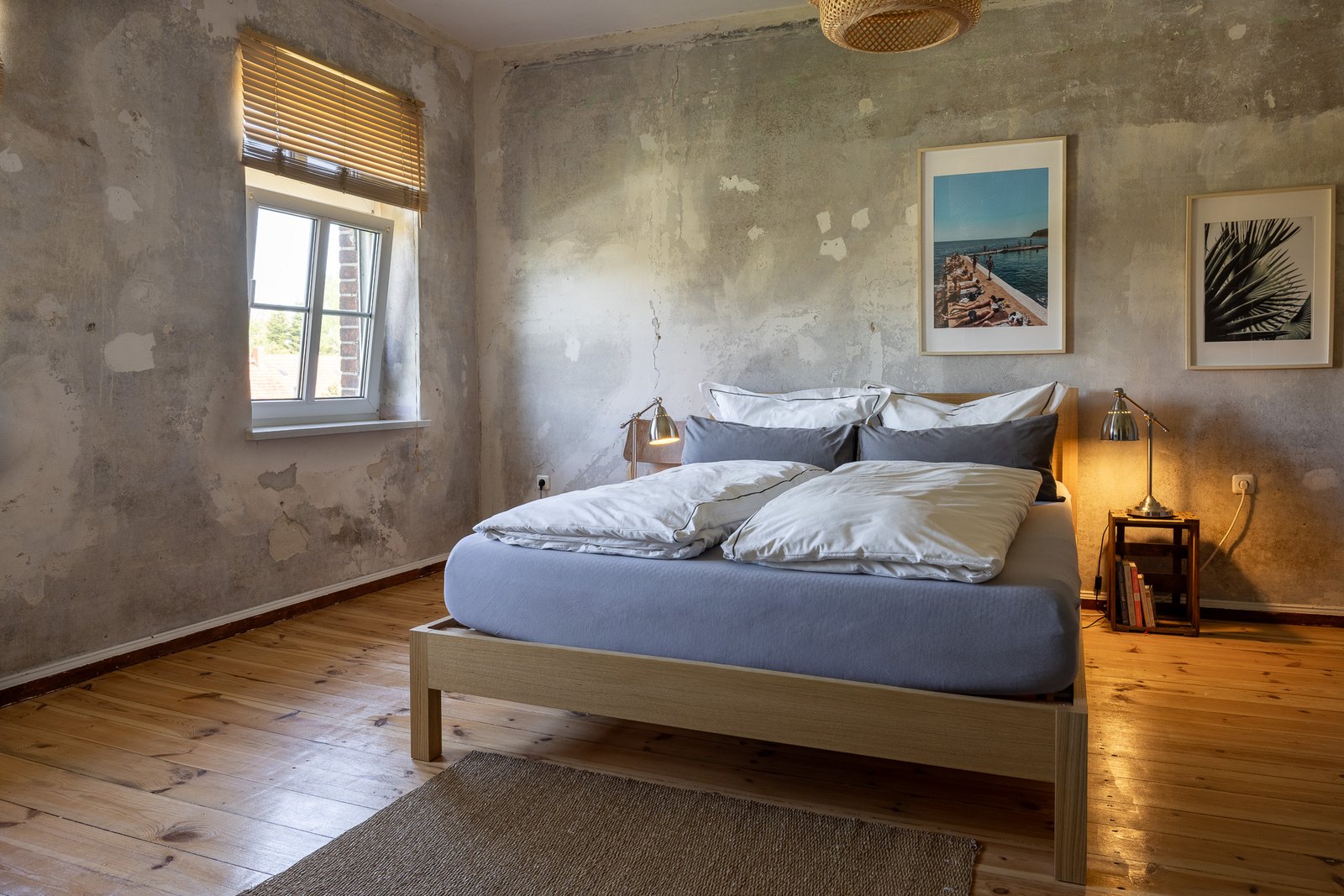Schlafzimmer im Obergeschoss mit Doppelbett, Holzdielen und Bildern an der Wand