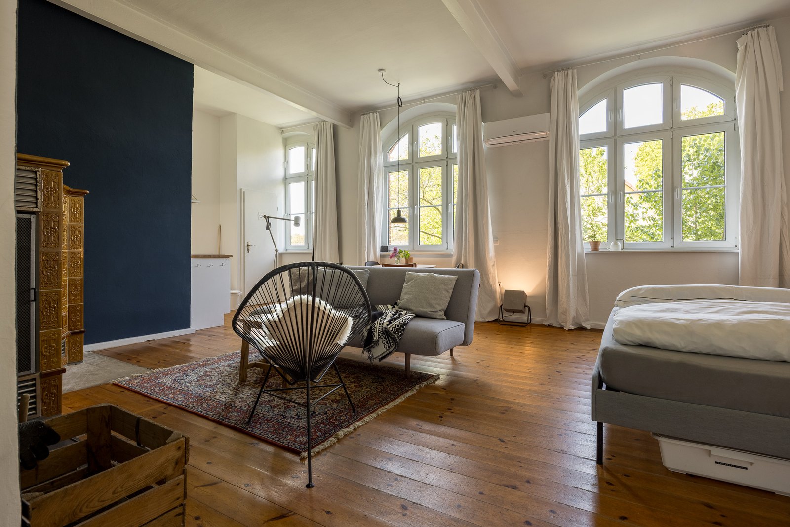 Sitzecke mit Sofa und Sessel vor den hohen Rundbogenfenstern