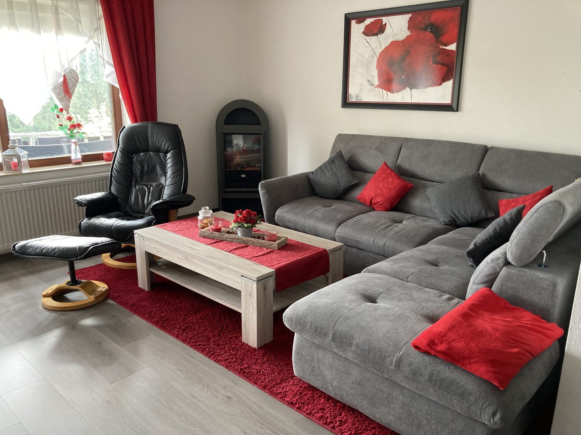 Sitzecke mit Ecksofa, Sessel und elektrischem Kamin