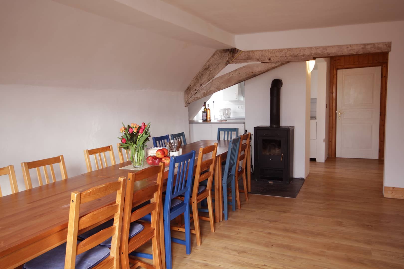 Großes Wohnzimmer mit langer Tafel und Kaminofen