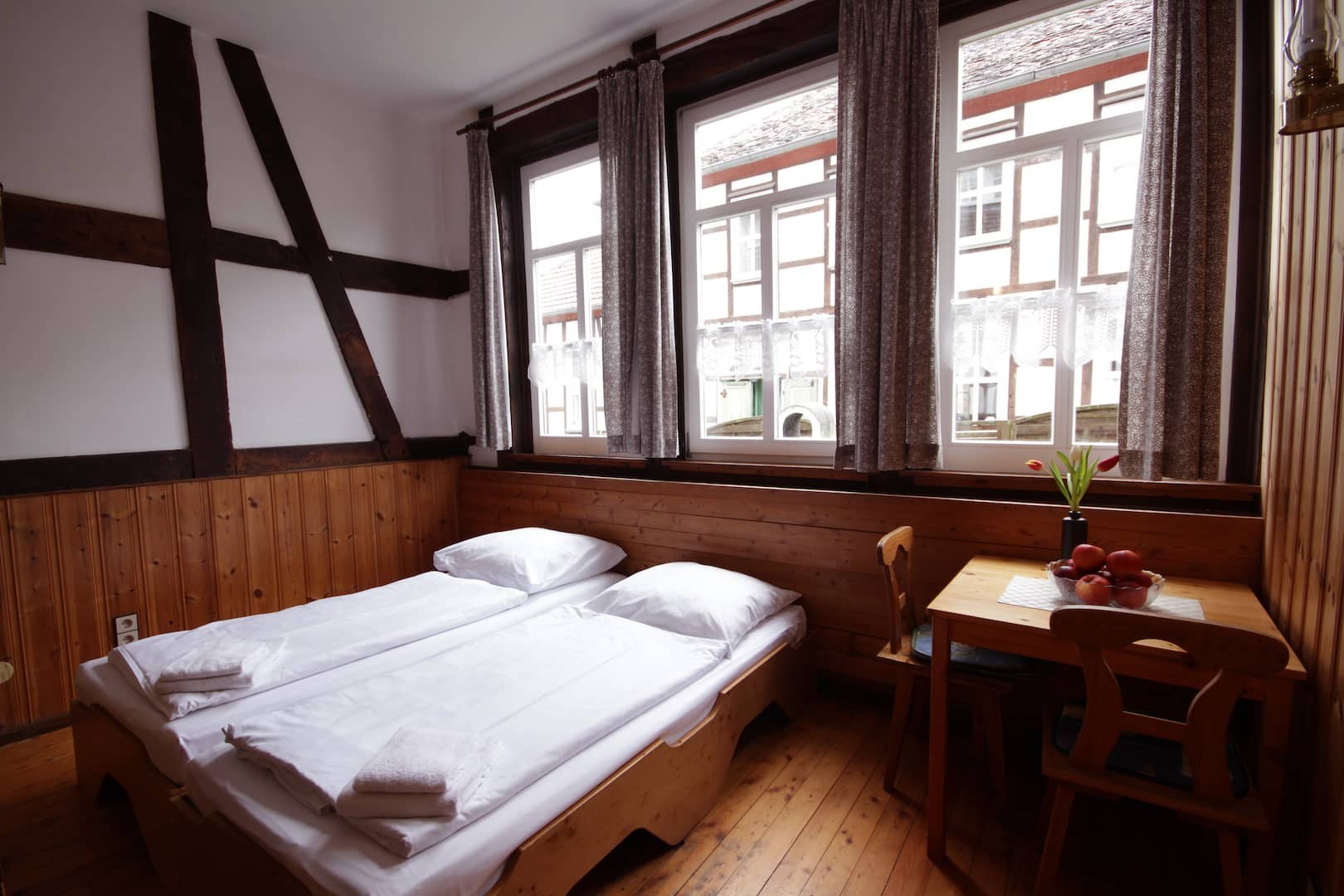 Zweibettzimmer mit Tisch und Blick in den Garten
