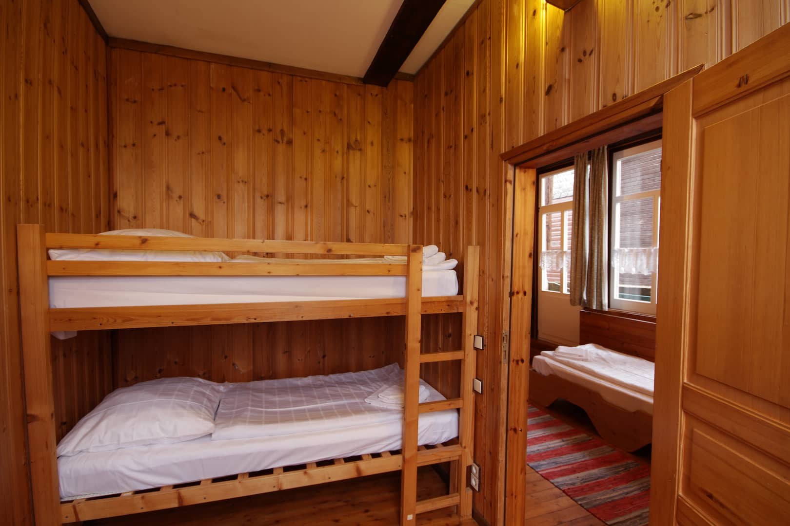 Zimmer mit Etagenbett und Holzwänden