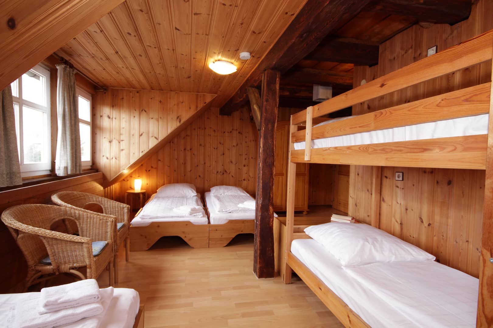 Schlafzimmer mit Einzelbetten, Etagenbett und Korbsesseln