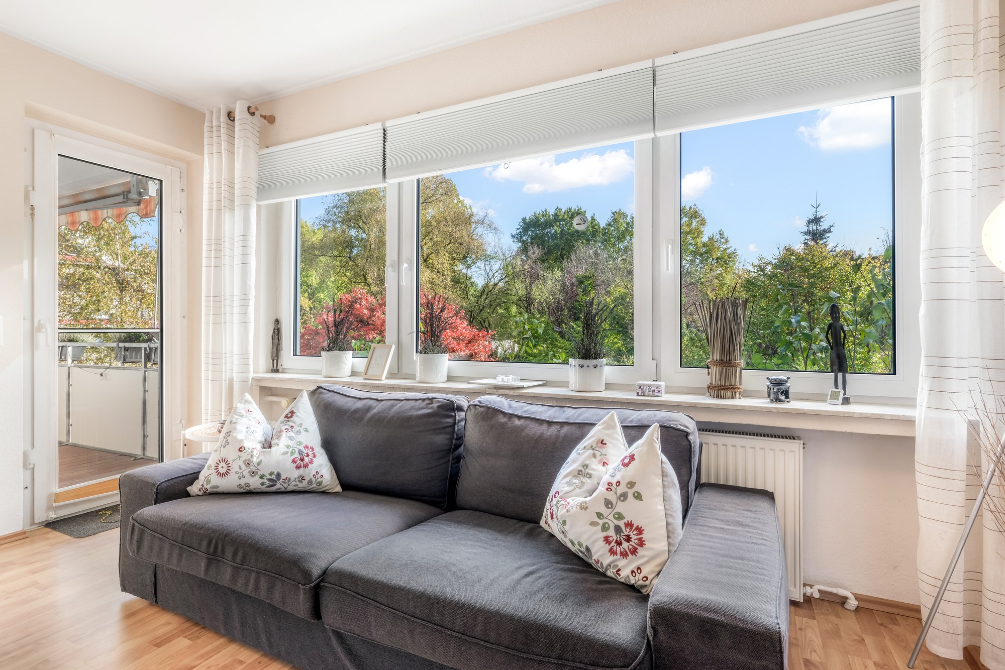 Sofa vor der Fensterfront, links die Tür zum Balkon