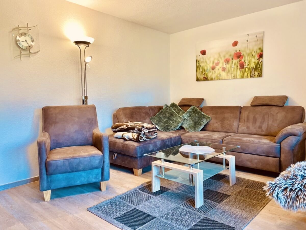 Wohnzimmer mit Ecksofa und Sessel im Ferienhaus Moi Stuuv